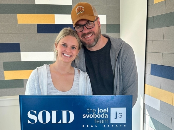 Happy homebuyers holding a “SOLD” sign from The Joel Svoboda Team Real Estate, celebrating their successful St. Louis home purchase.